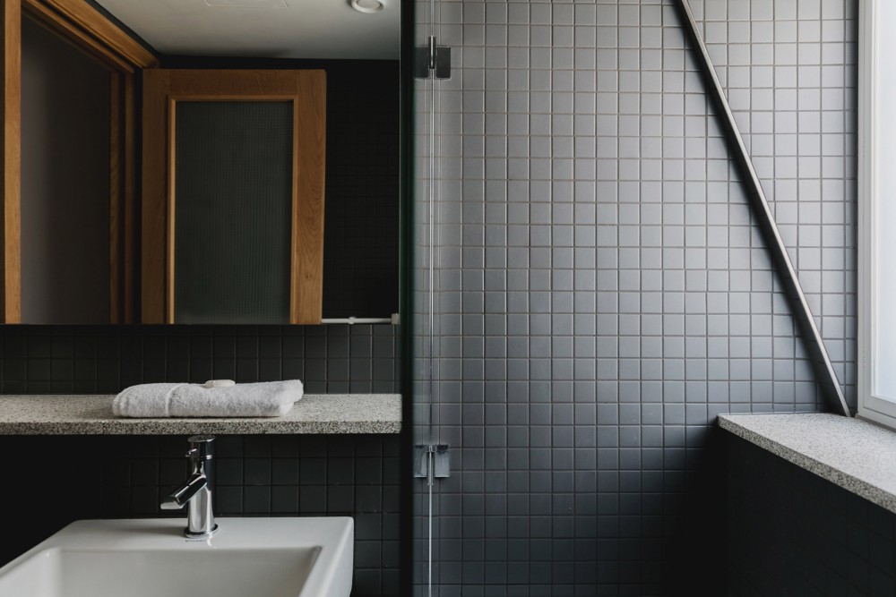 When-Not-To-Scrimp-on-Your-Renovation-Dark-Tiled-Bathroom